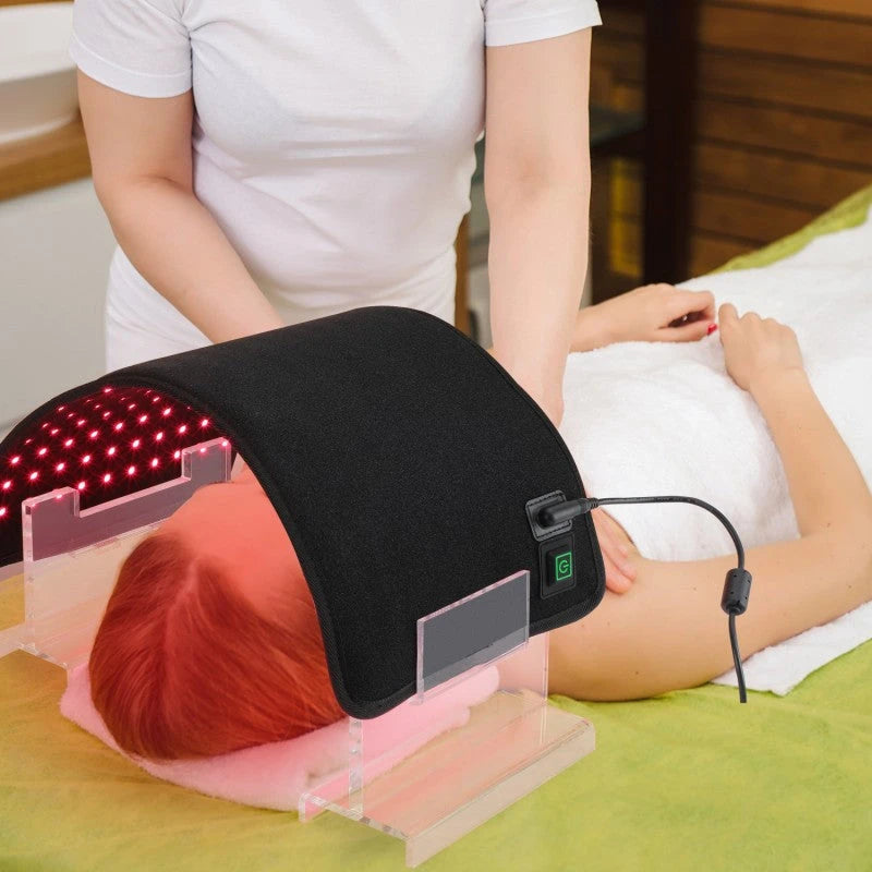 Person receiving LED light therapy on a green bed.